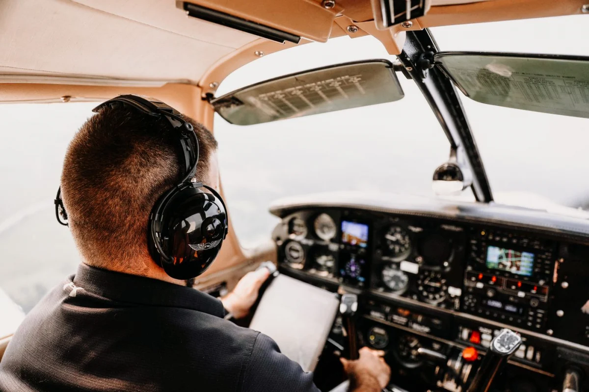 Pilot using a communication headset inside an aircraft cockpit