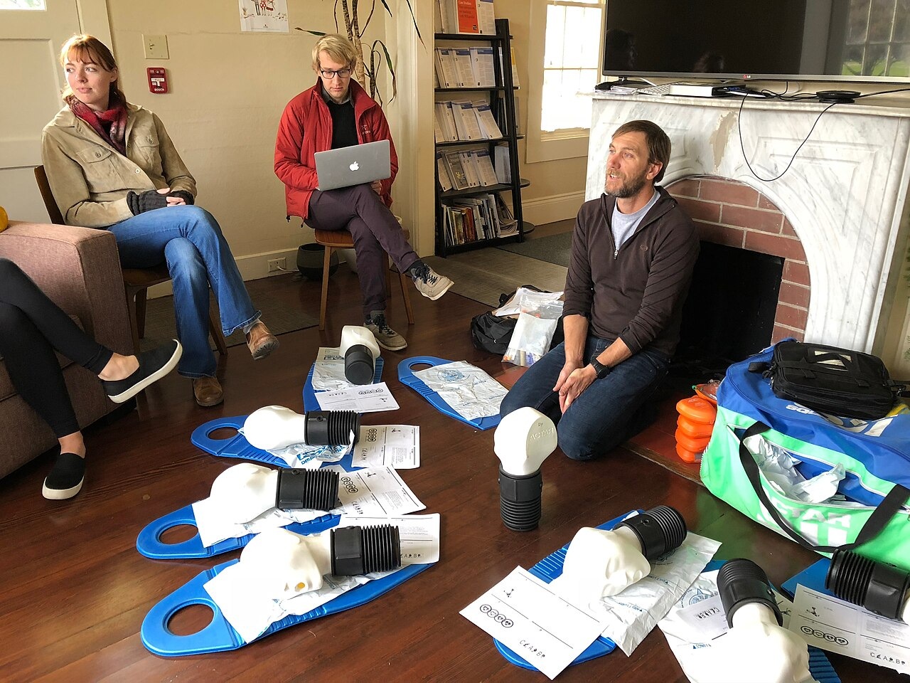 Real first aid training: instructor and learners practising on a manikin
